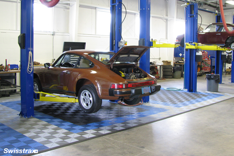 Swisstrax garage floor tiles installed underneath a car lift
