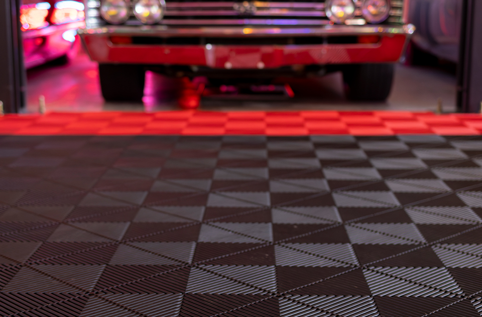 Close up of red and black Swisstrax tiles with classic car in background