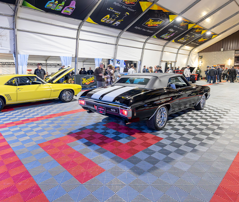 Yellow and black classic cars on Swisstrax tiles under Event Tent