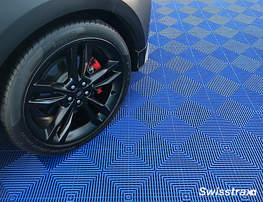 Closeup view of Ribtrax Pro floor tiles at an outdoor car show