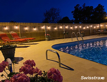 Night view of Ribtrax Smooth Pro tiles installed around a backyard pool